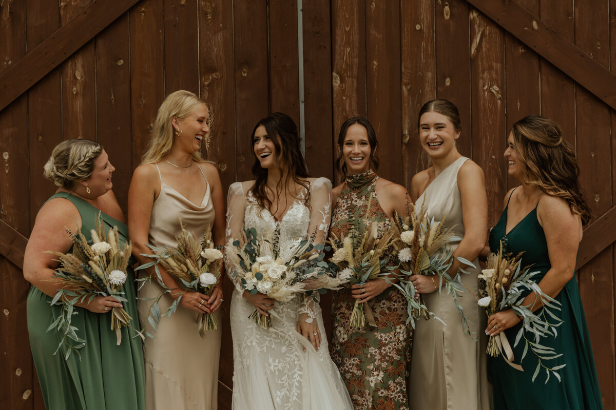 Bride and groom walking with wedding party and everyone is laughing captured by MN Wedding Photographer 