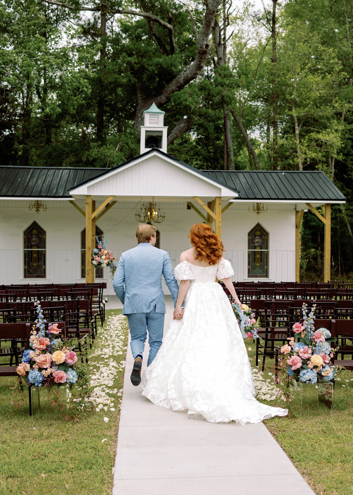 Bride and groom walking in the aisle in lace gown in Wilmington, NC wedding photography