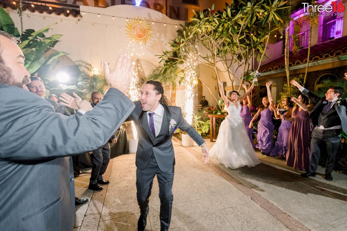 Groom high fives guests after entering the reception area