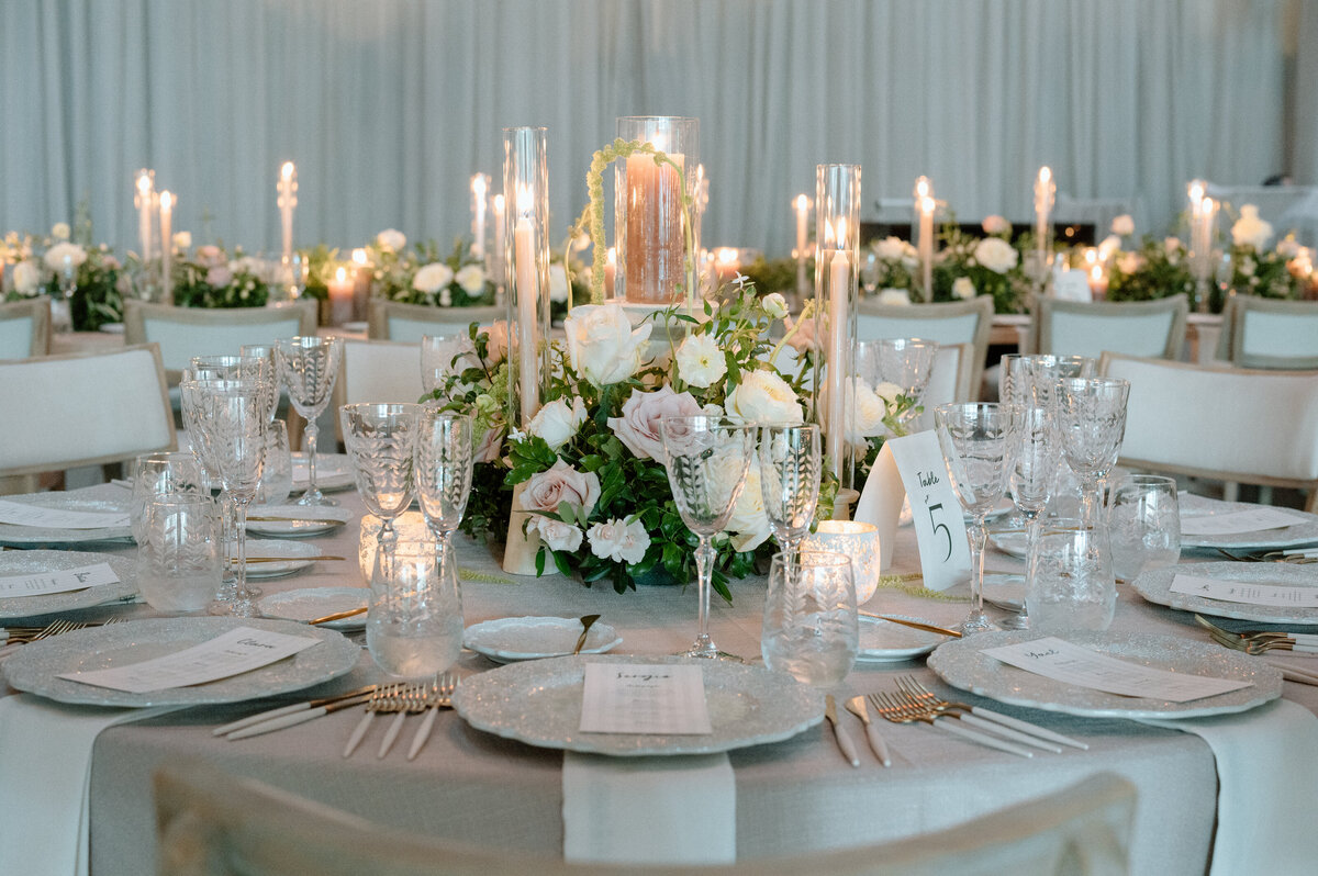 Candlelit tables with lush white florals and neutral tones.