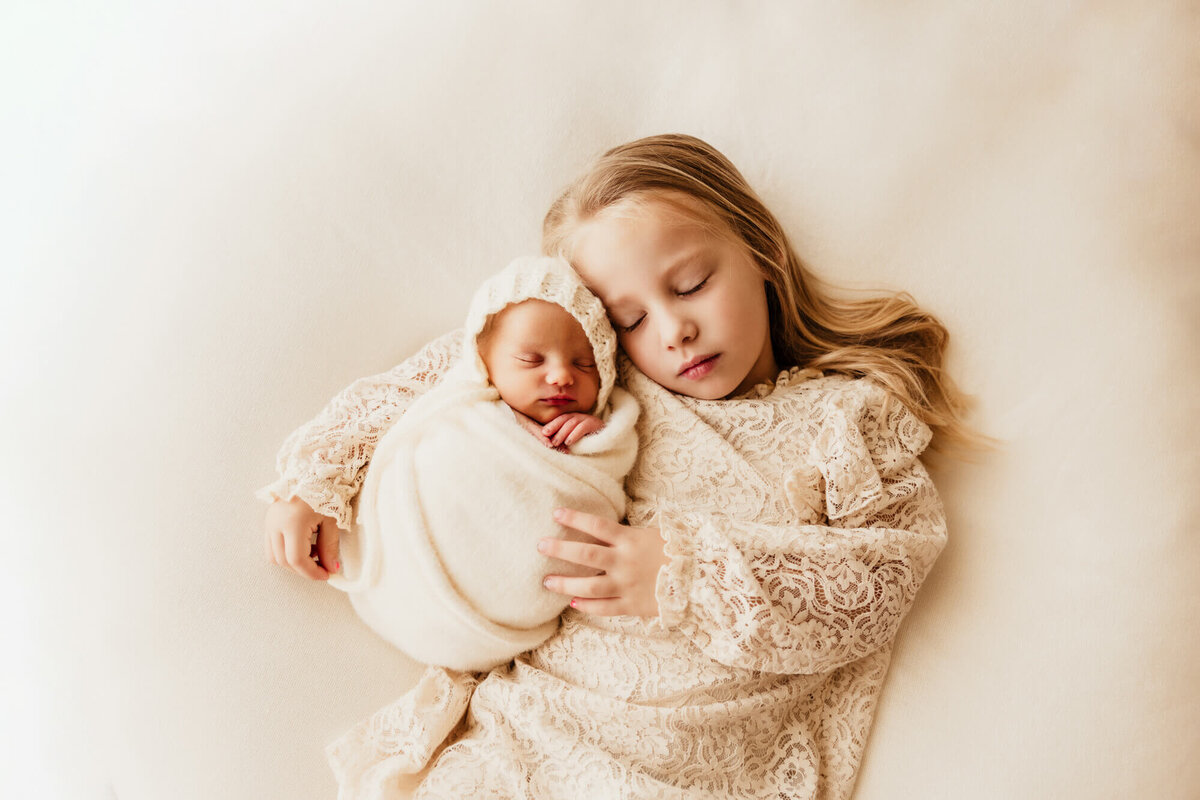 Sibling portrait of a girl with her newborn baby sister in Oklahoma City.