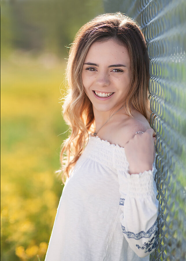 senior-girl-pretty-bokeh-flowers-fence-castle-rock