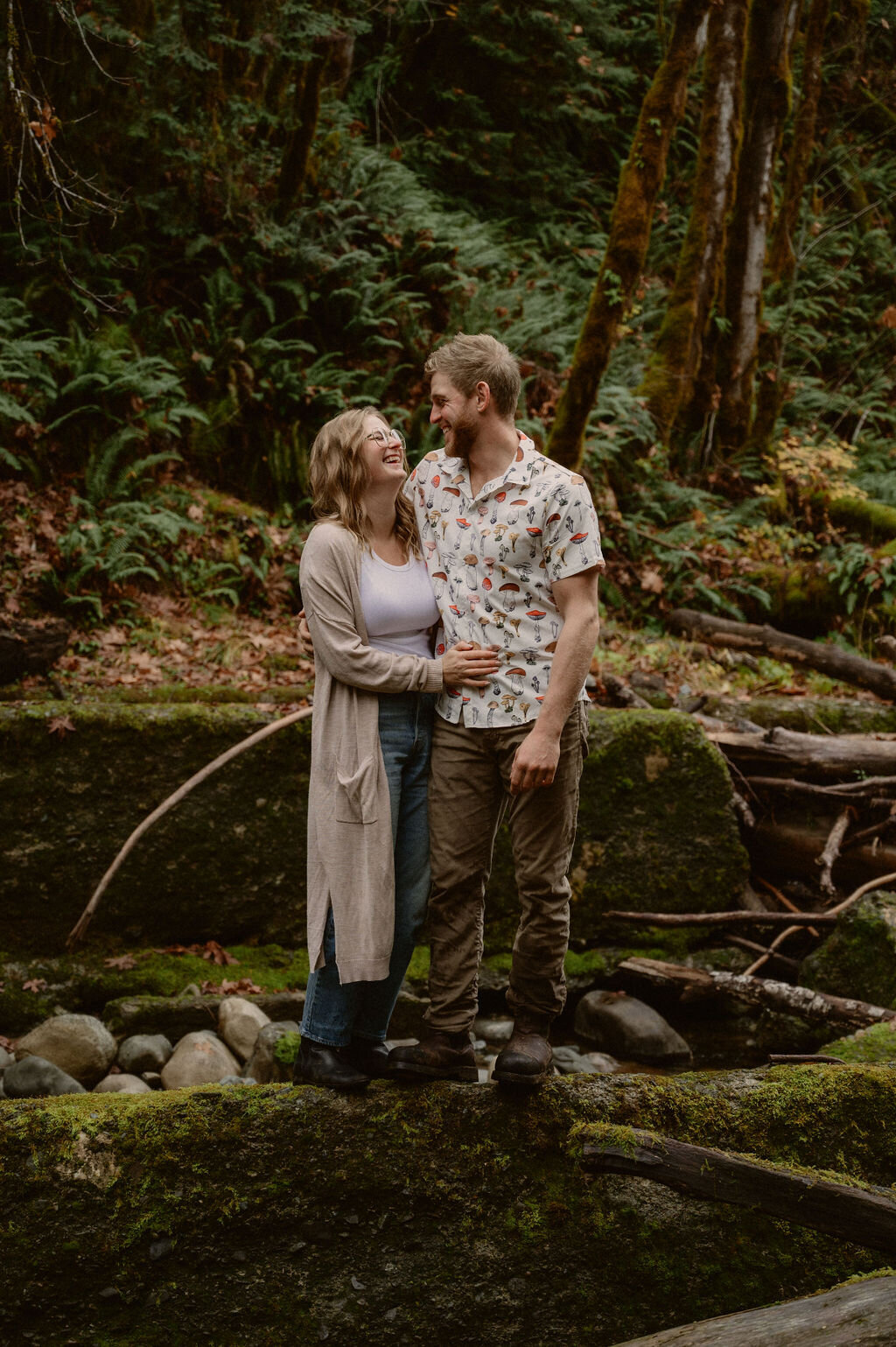 Couple side hugging on concrete wall in forest in Port Alberni