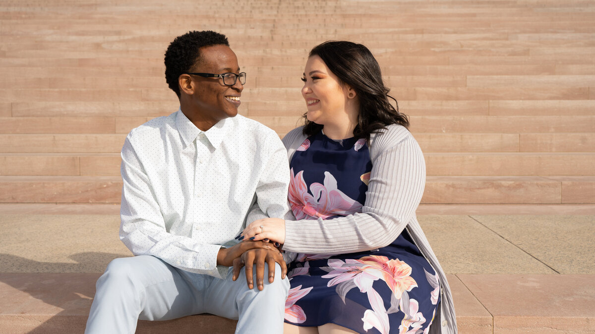 A couple sits on the steps of the National Art Gallery in Washington, DC.