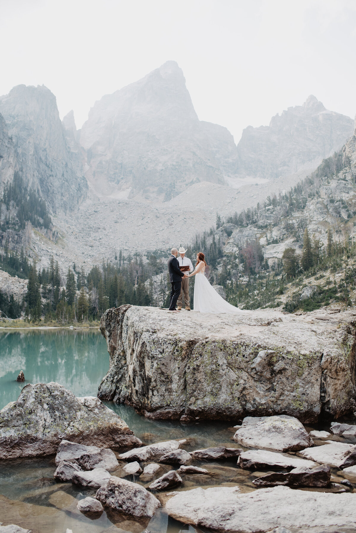 Jackson Hole photographers capture bride and groom holding hands at wedding ceremony
