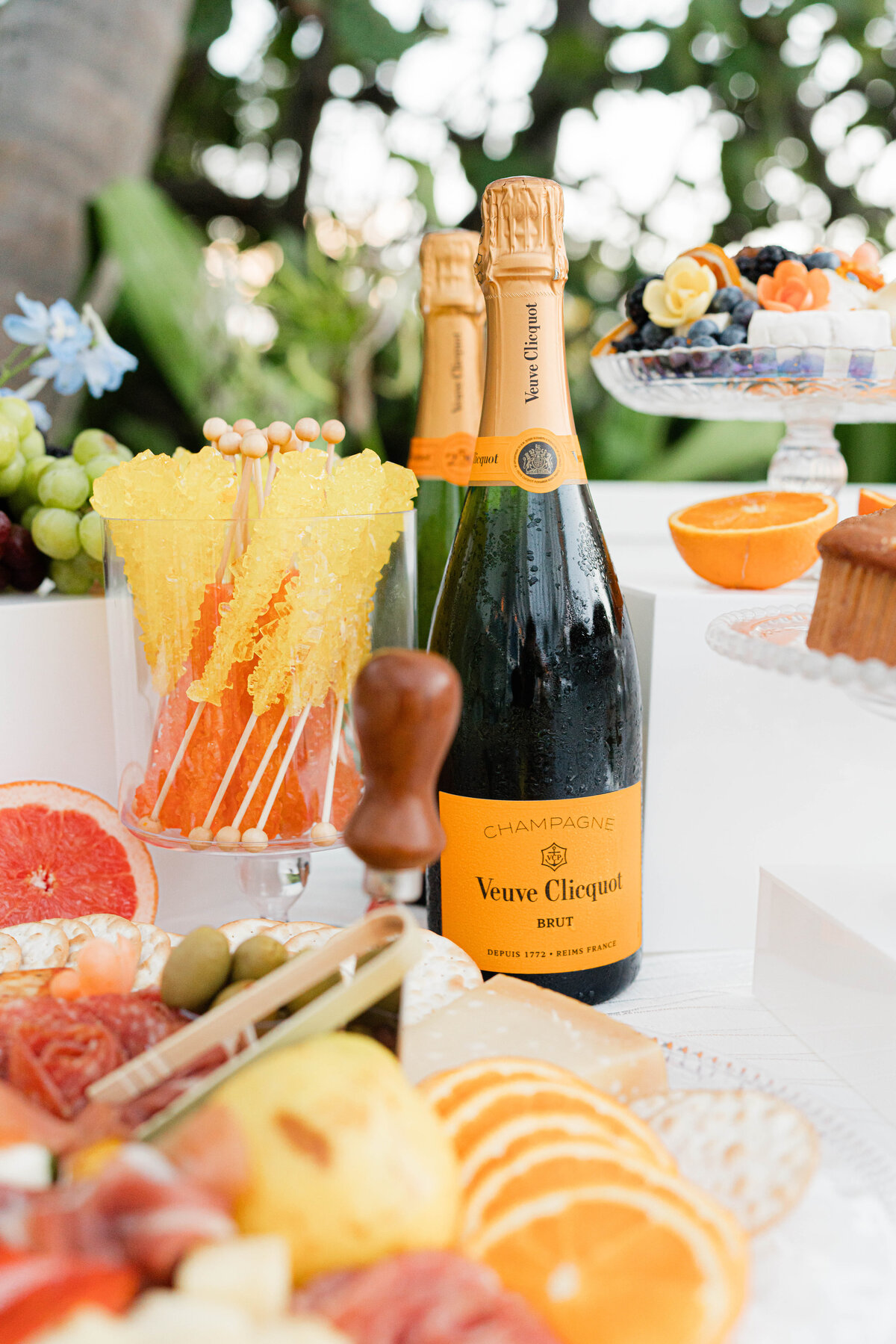 partial view of brunch breakfast spread with bottles of champagne and assorted fruit