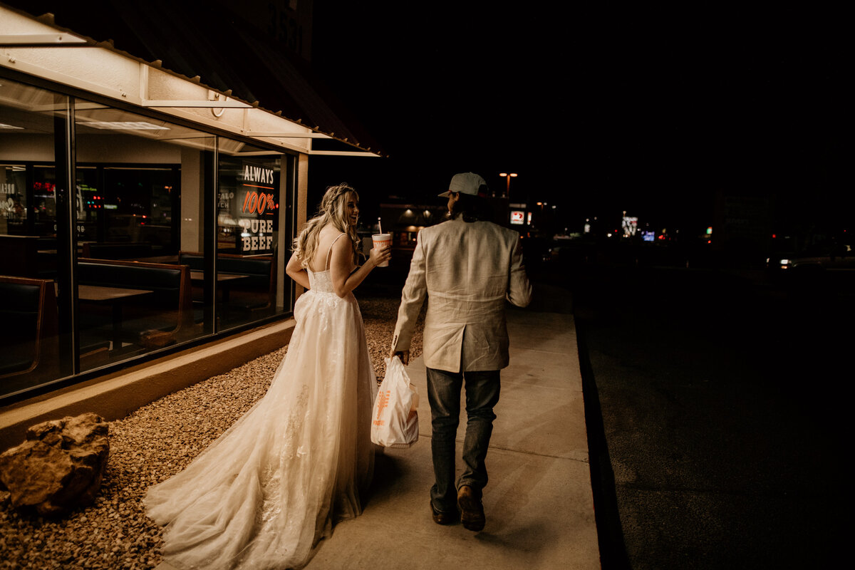 bride and groom eating dinner in wedding attire at Whataburger