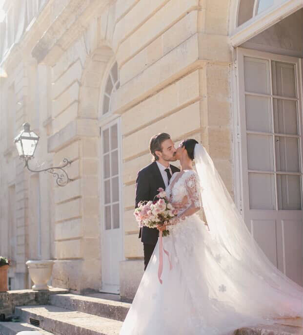 bride and groom kissing near a building in Italy