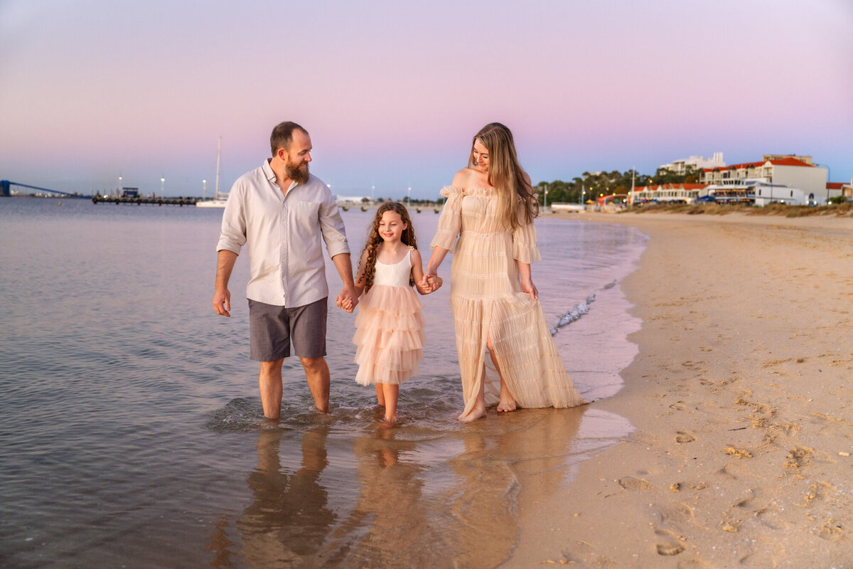 A family strolls the beach during a family photshoot