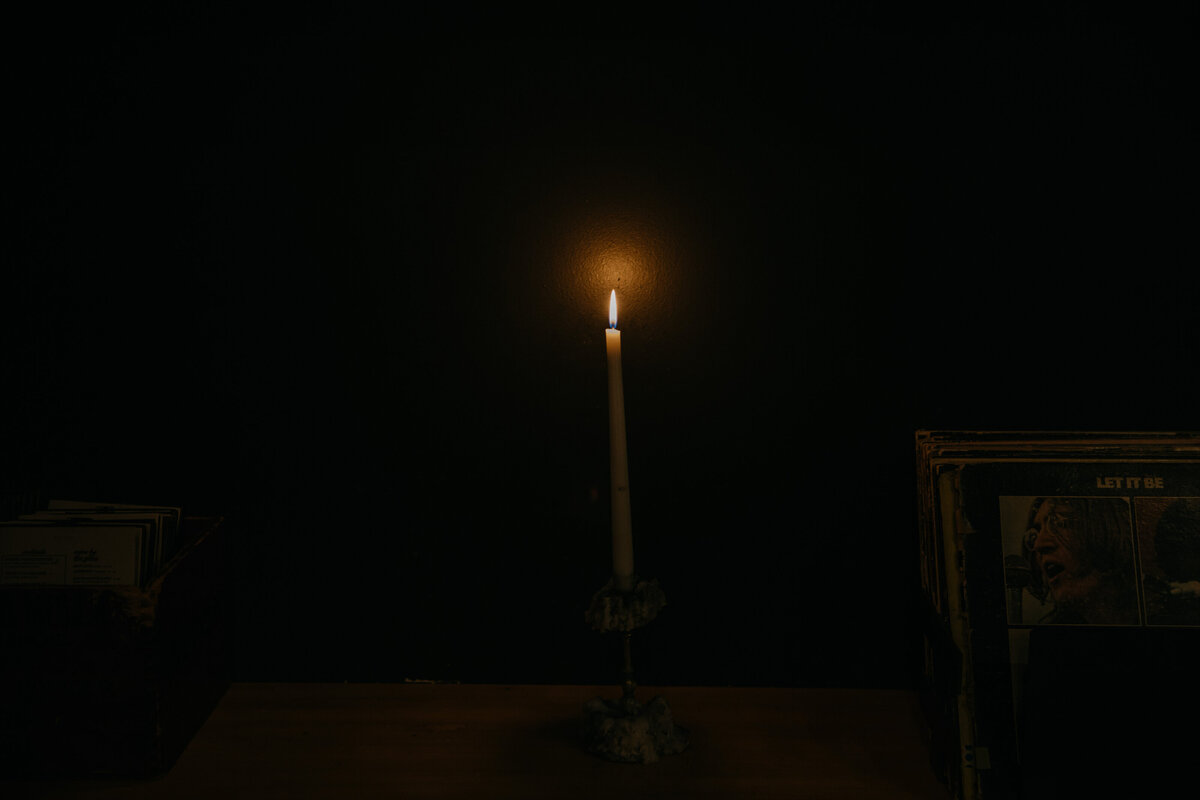 Single lit illuminated candle surrounded by darkness