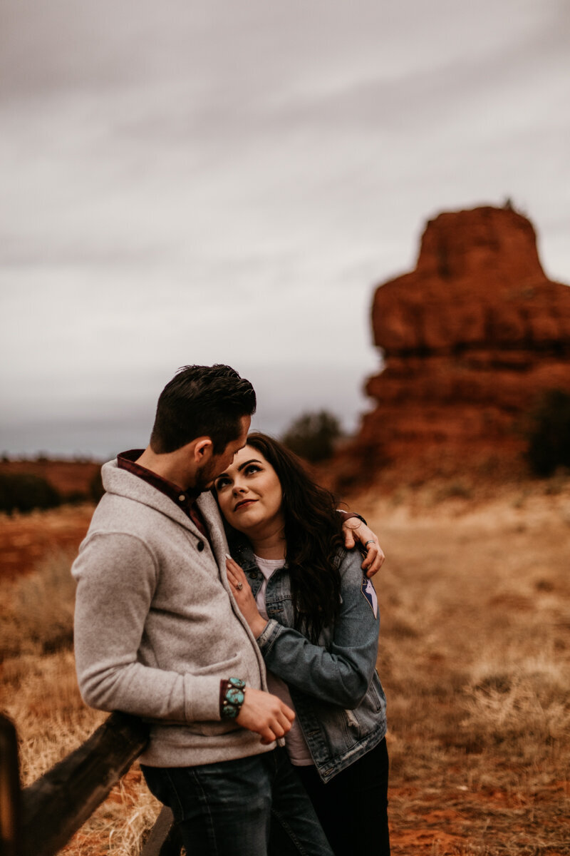 woman leaning on fiancé in desert