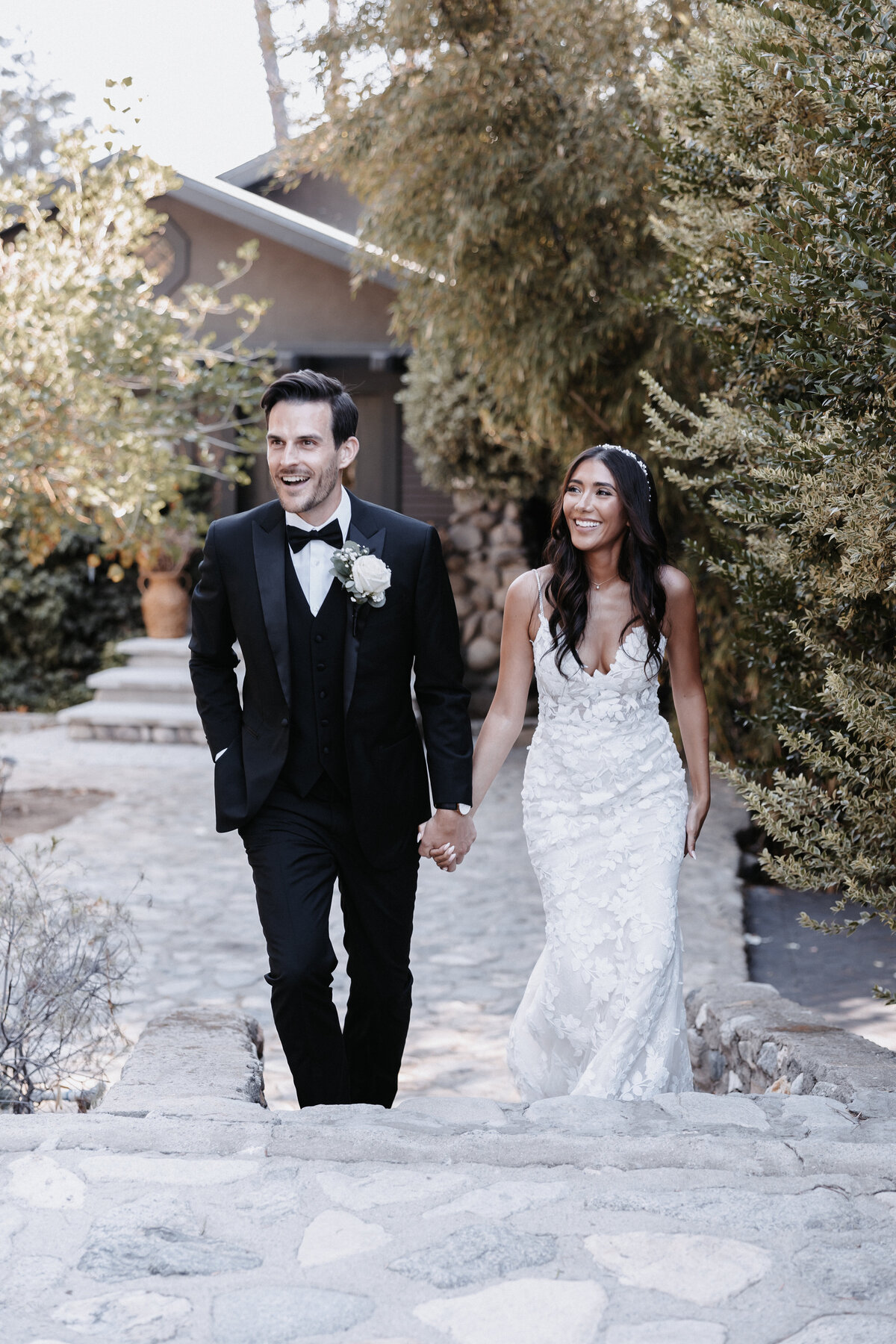Elopement photographer, bride and groom holding hands walking up steps looking joyful