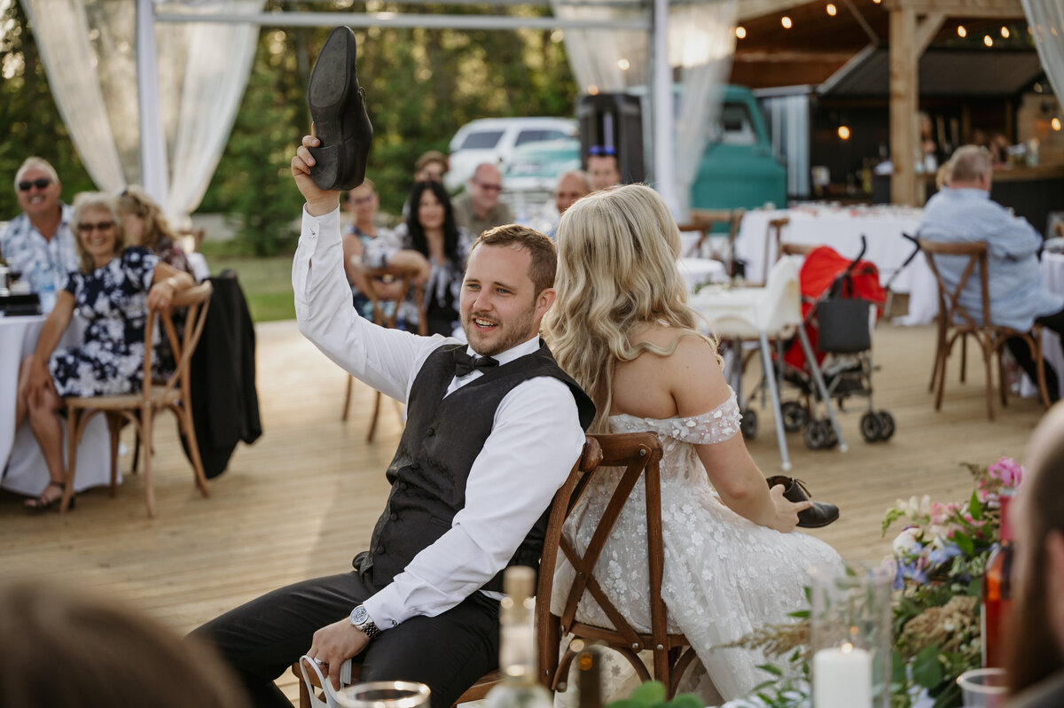 groom playing shoe game with wife at alberta reception