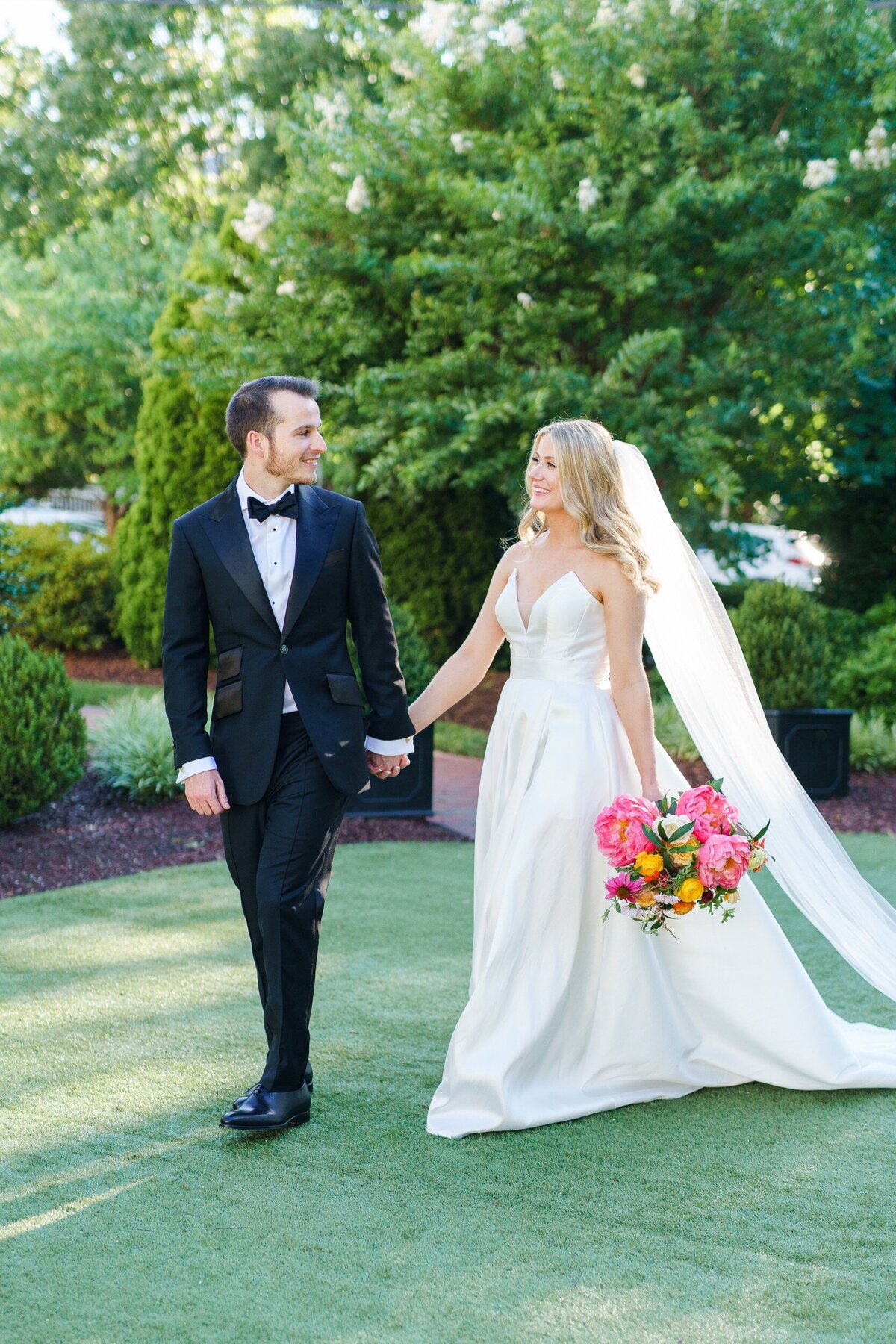 Couple walks hand in hand during Raleigh wedding by photographer Jenn Eddine