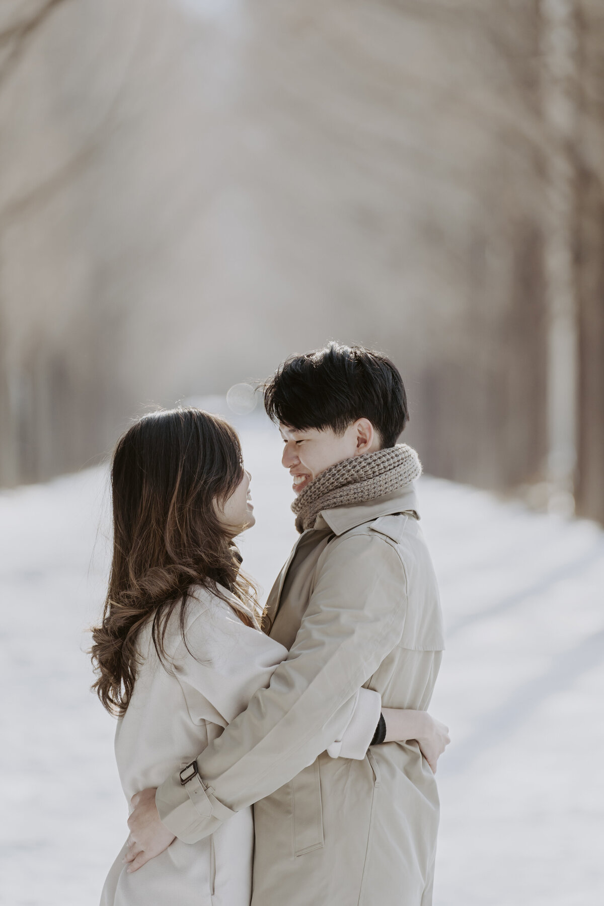 the couple hugging while staring at each other in a winter snow in damyang south korea