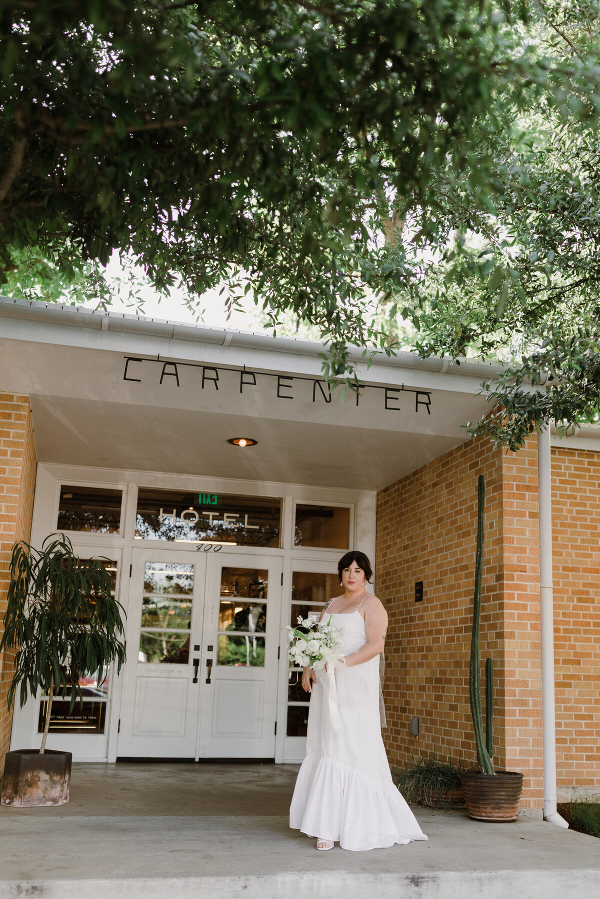 Bride outside the entrance to the Bride and groom portraits at  Carpenter Hotel, Austin
