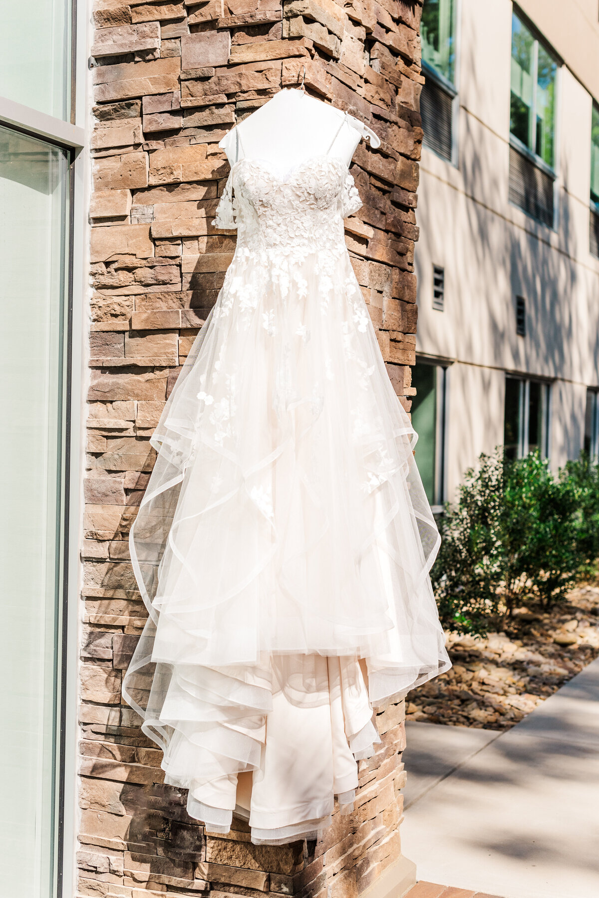 wedding dress covered in lace and tulle outside on bricks