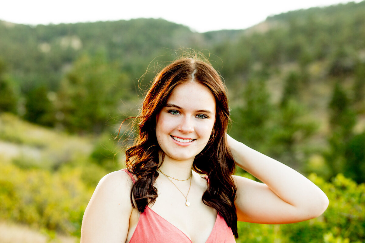 girl in peach dress touches hair