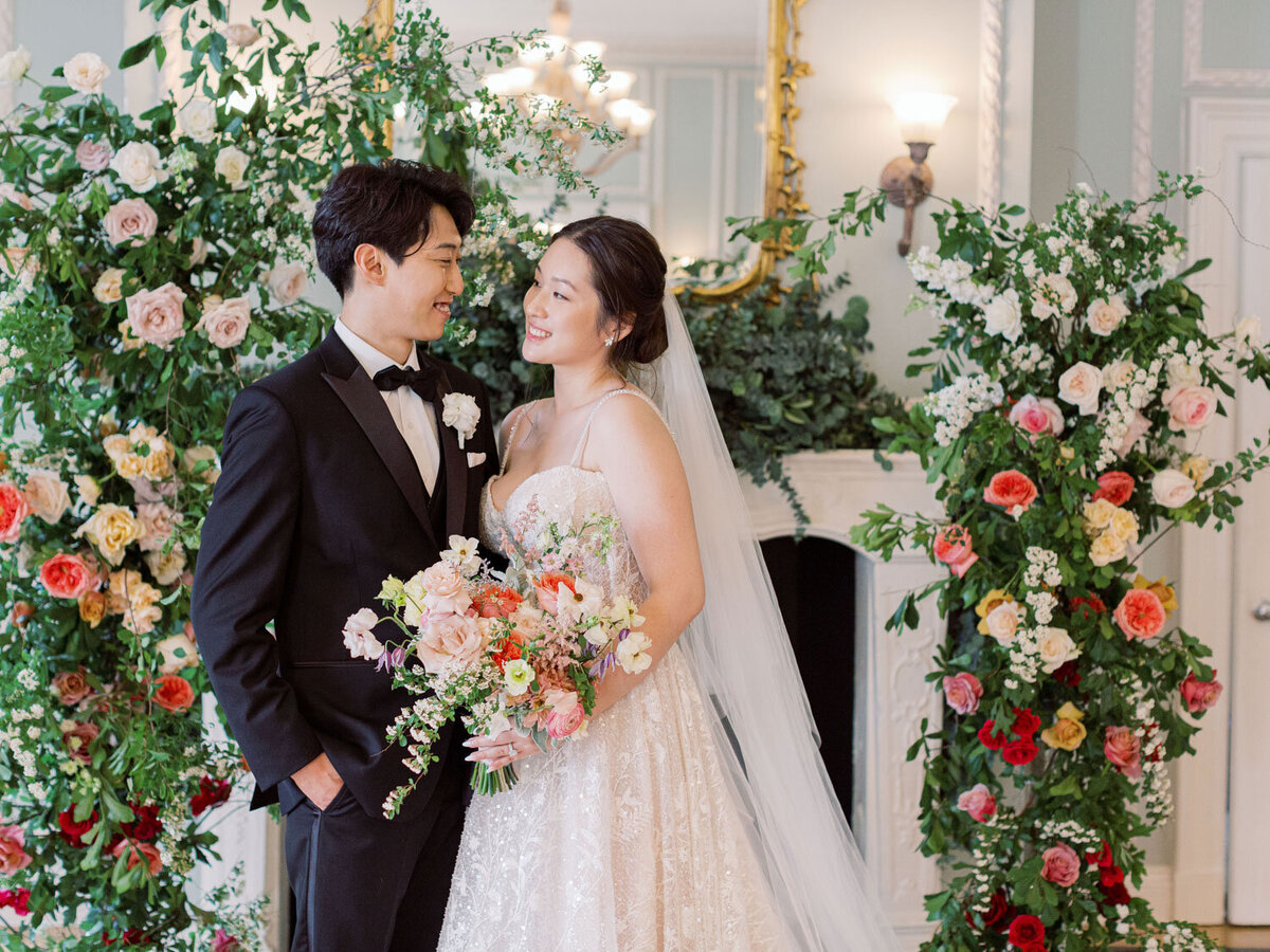 Bride and groom pose together with bouquet