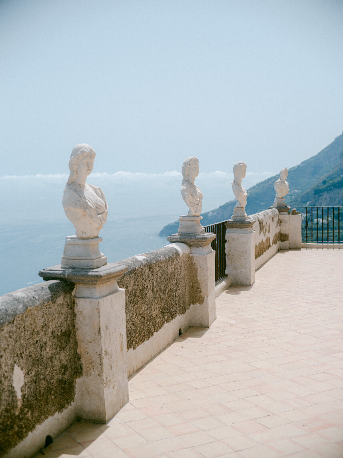 Scenic terrace at Villa Cimbrone in Ravello with marble busts overlooking the Mediterranean — iconic setting for Amalfi Coast weddings.