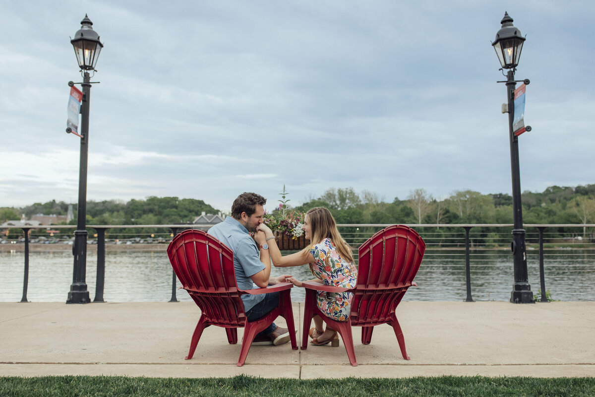Couple kissing hands during engagement session by Delaware River in New Hope Pennsylvania
