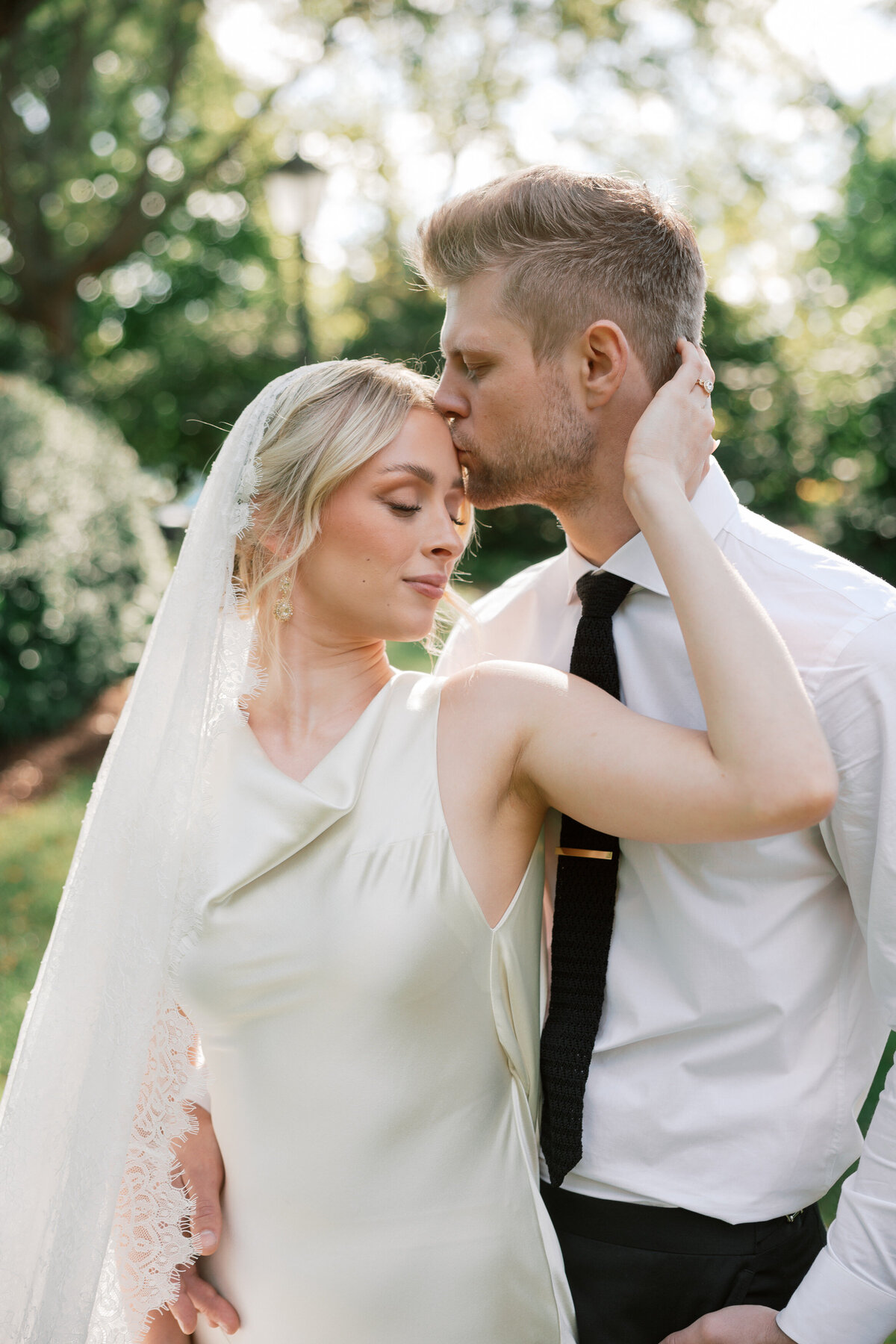 Groom kisses bride’s forehead at their romantic Dayton, Ohio wedding, captured by a Philadelphia-based photographer.