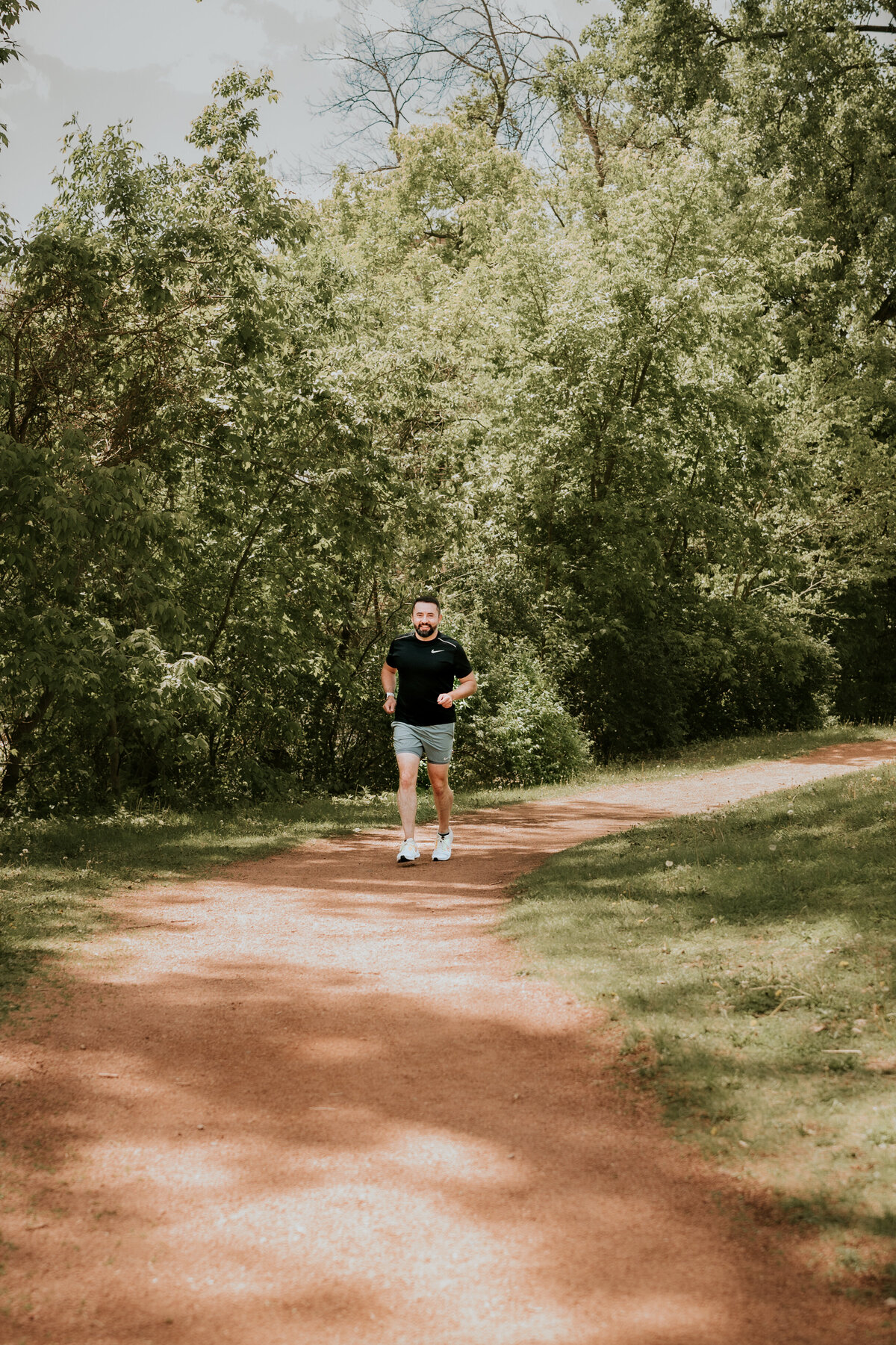 A man jogging along a Minneapolis river trail, captured for an active online dating profile that highlights his energetic and outdoorsy lifestyle.