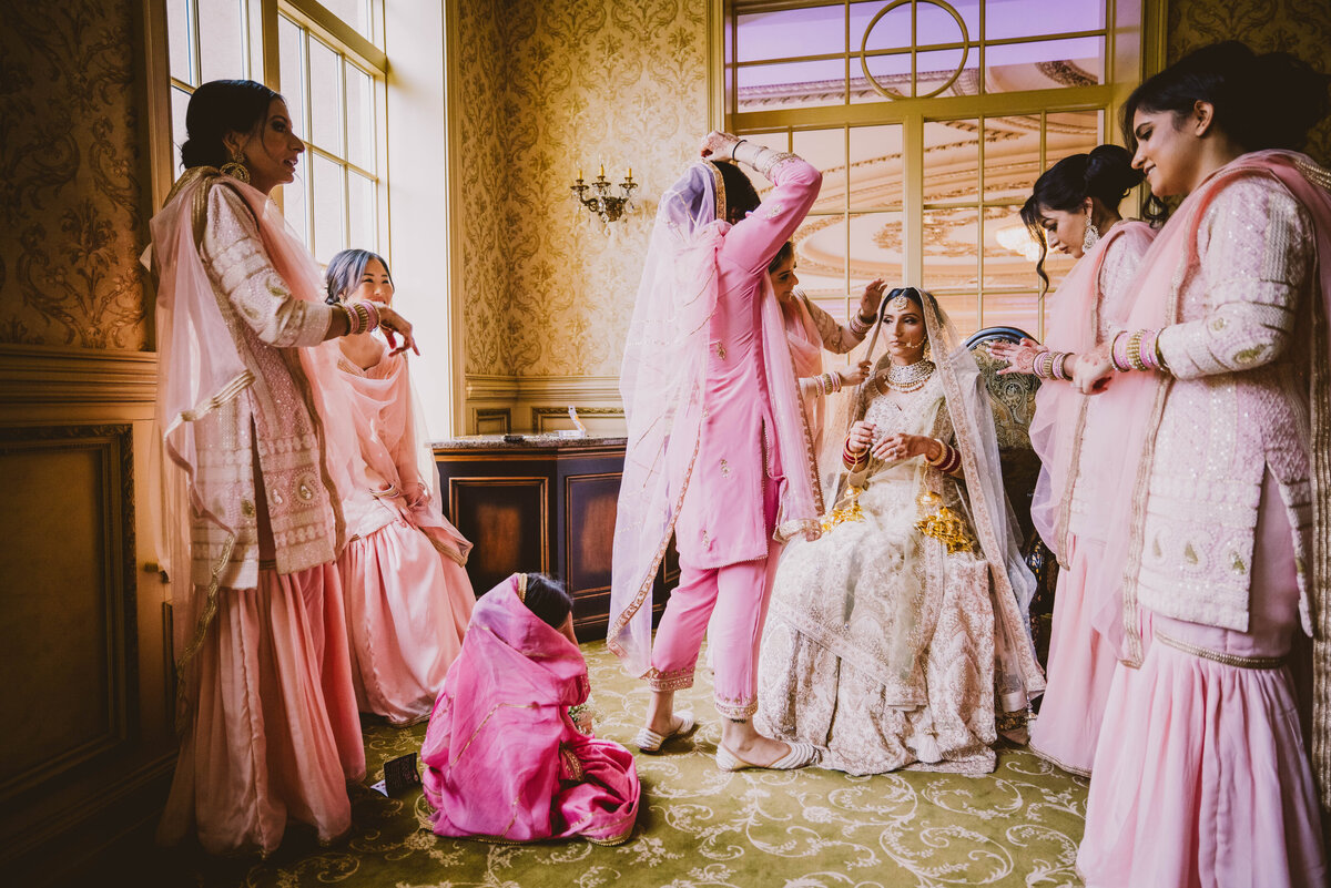 Busy bridesmaids getting ready with the bride on the sikh wedding day in the bridal suite at Brigalias nj 