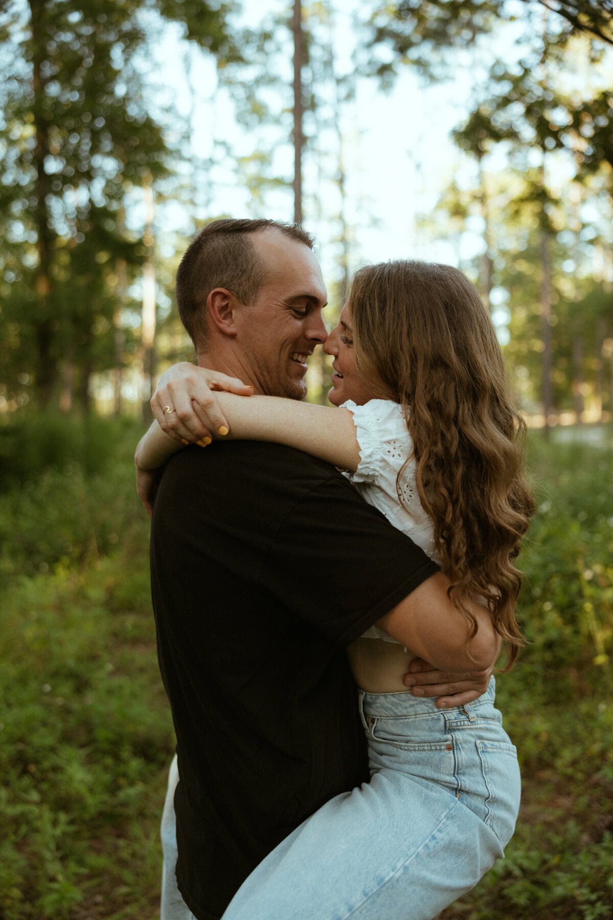 Couple posing for portraits in a forest.
