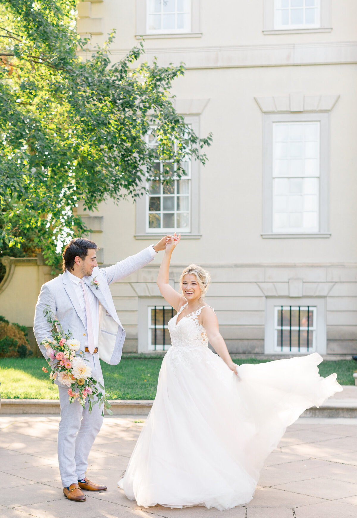 Groom twirling Bride in front of Great Marsh Estate in Bealeton, Virginia. Taken by Charlottesville Wedding Photographer Bethany Aubre Photography.