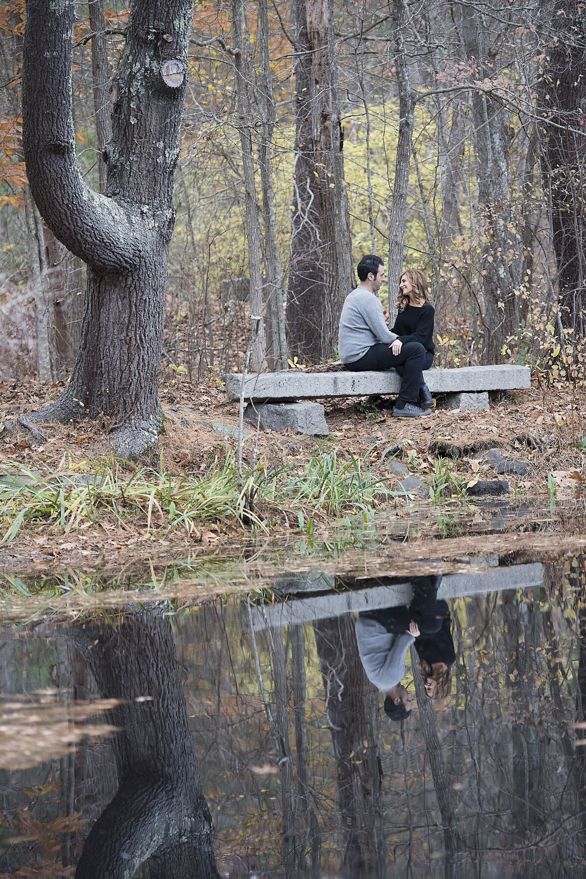 A couple sitting on a bench next to the water