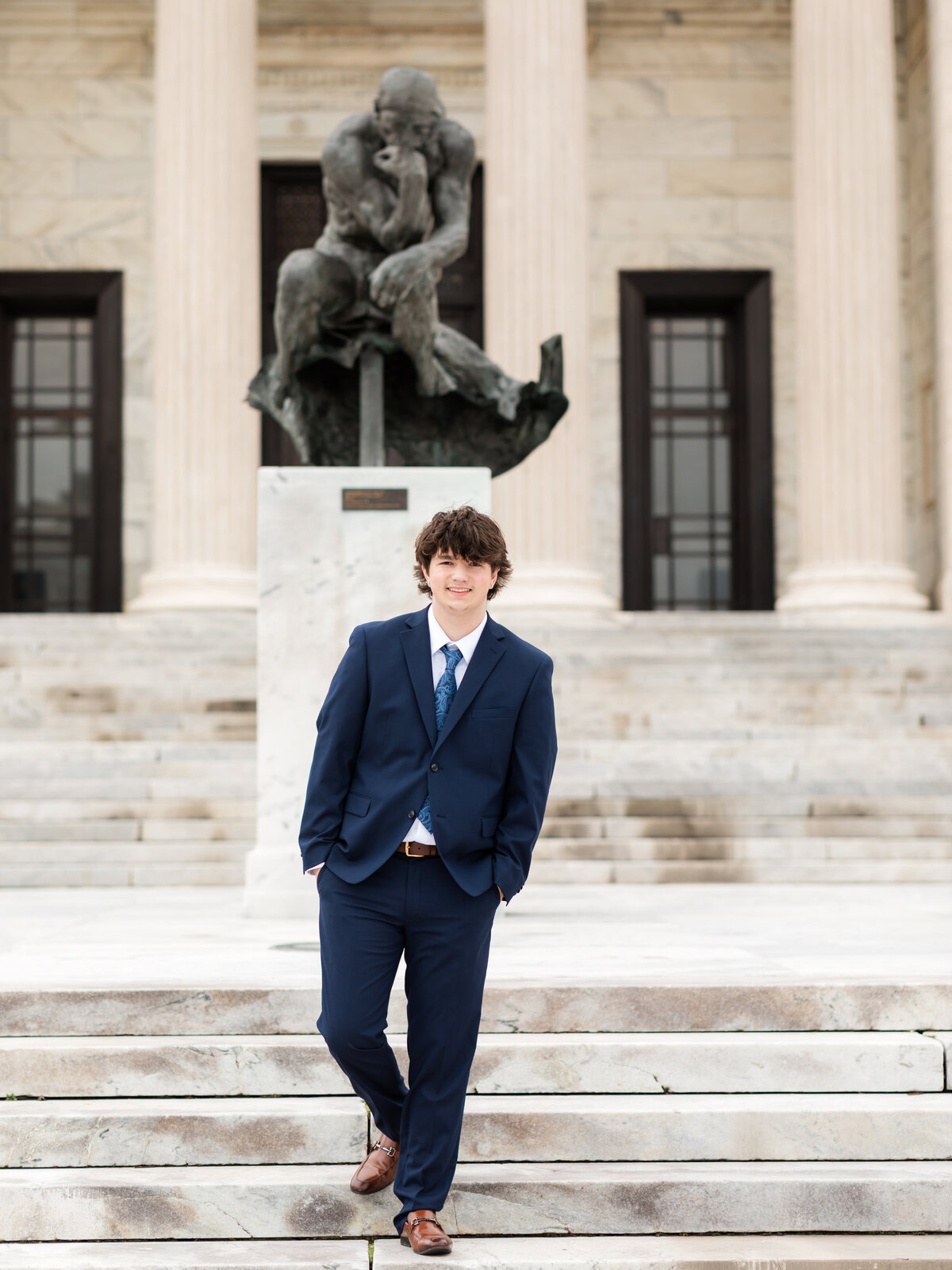 high school senior boy in blue suit posed at Cleveland Museum of Art for portraits