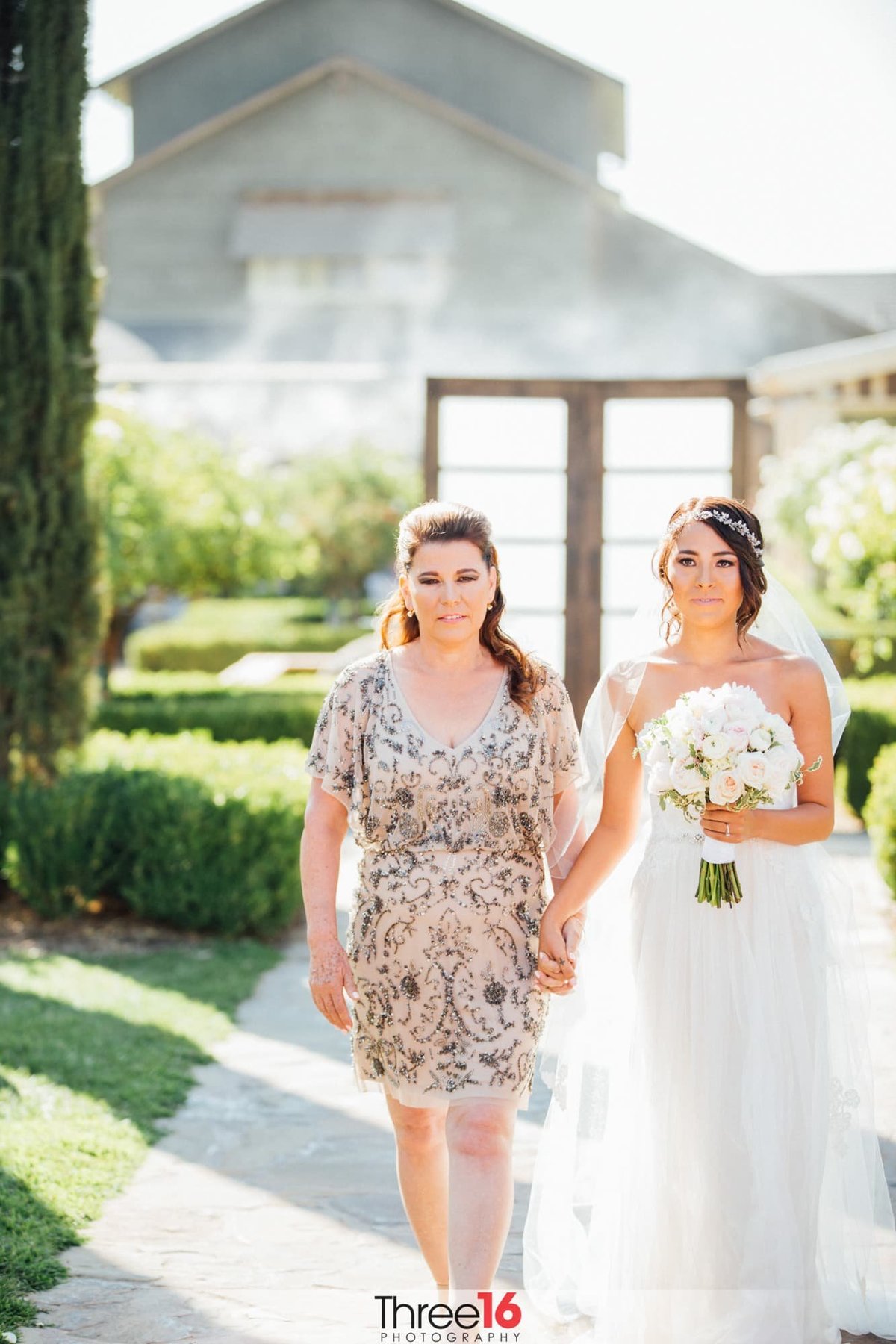 Bride and her mom walk down the aisle
