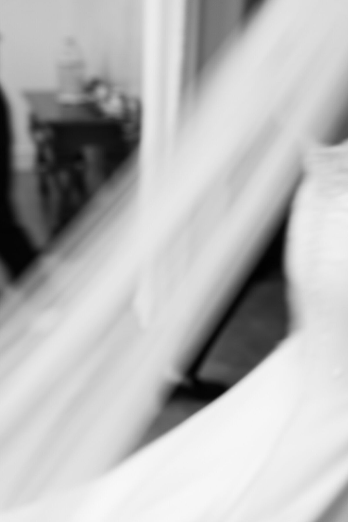 Abstract blurred black and white photo of bride’s wedding gown and veil