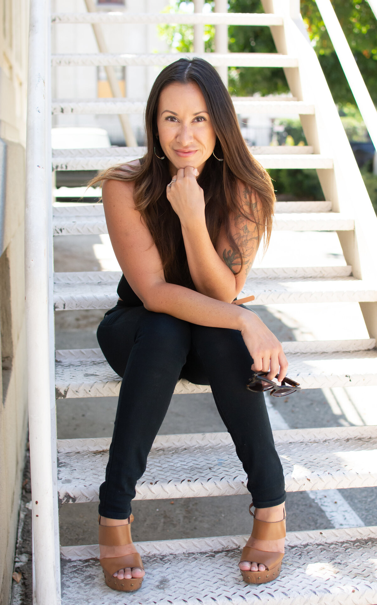 Business Headshot Photography. Female sitting on steps outdoors in all black.