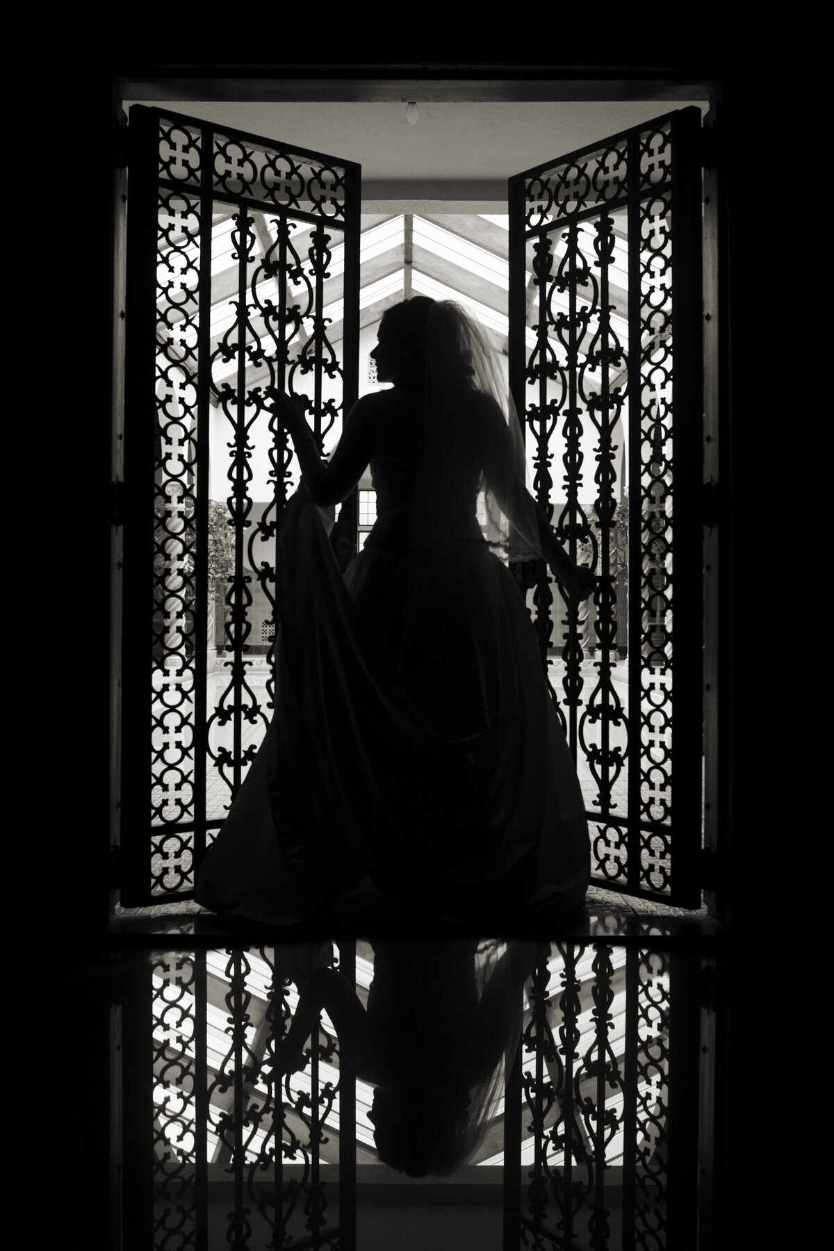 A newlywed walking out of an iron gate 