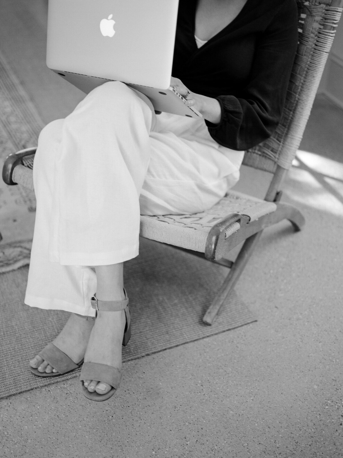 crop of designer working in chair, white pants, sandals, Fernhaus Michigan branding photography