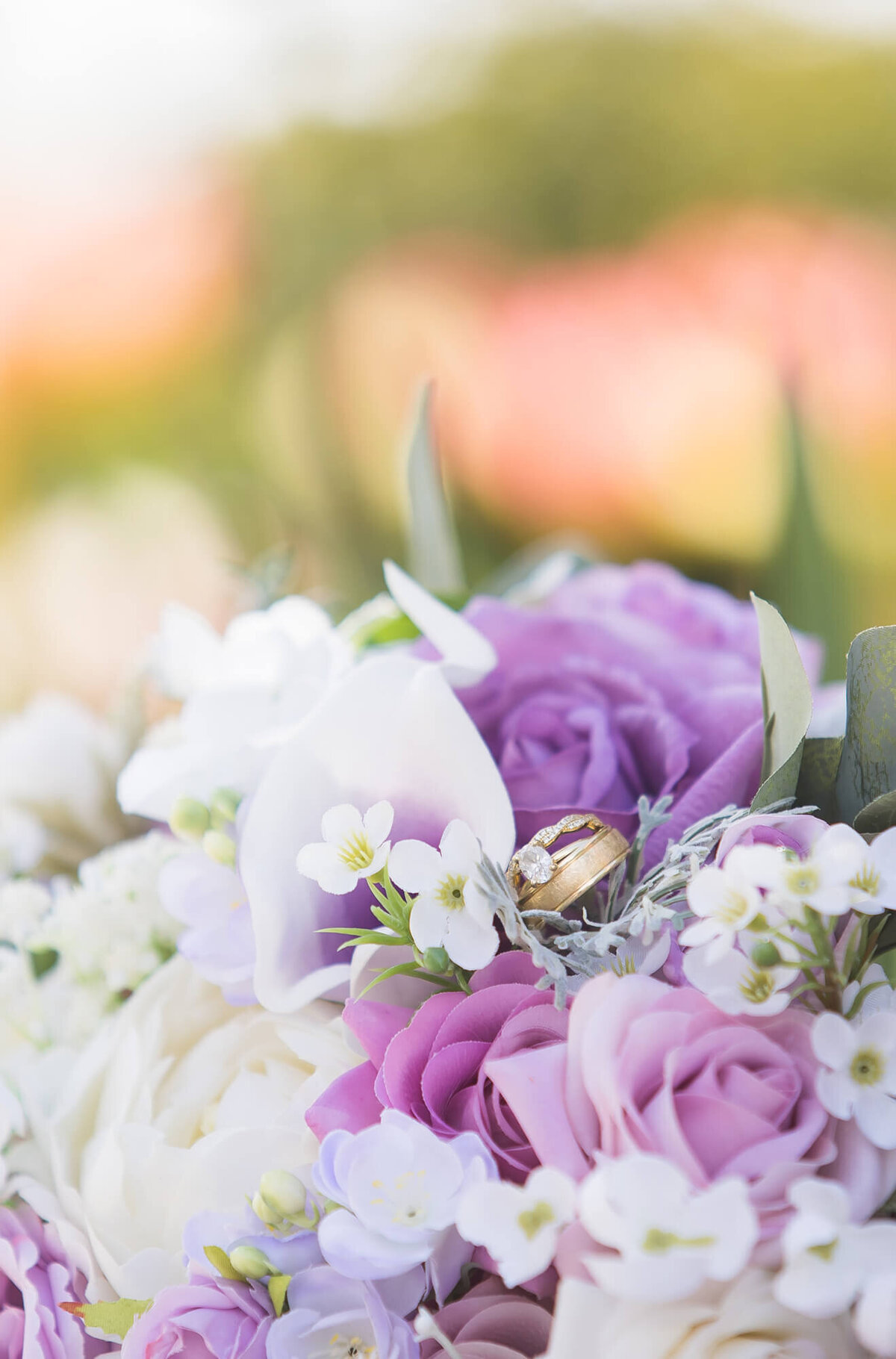 wedding rings in a purple rose bouquet