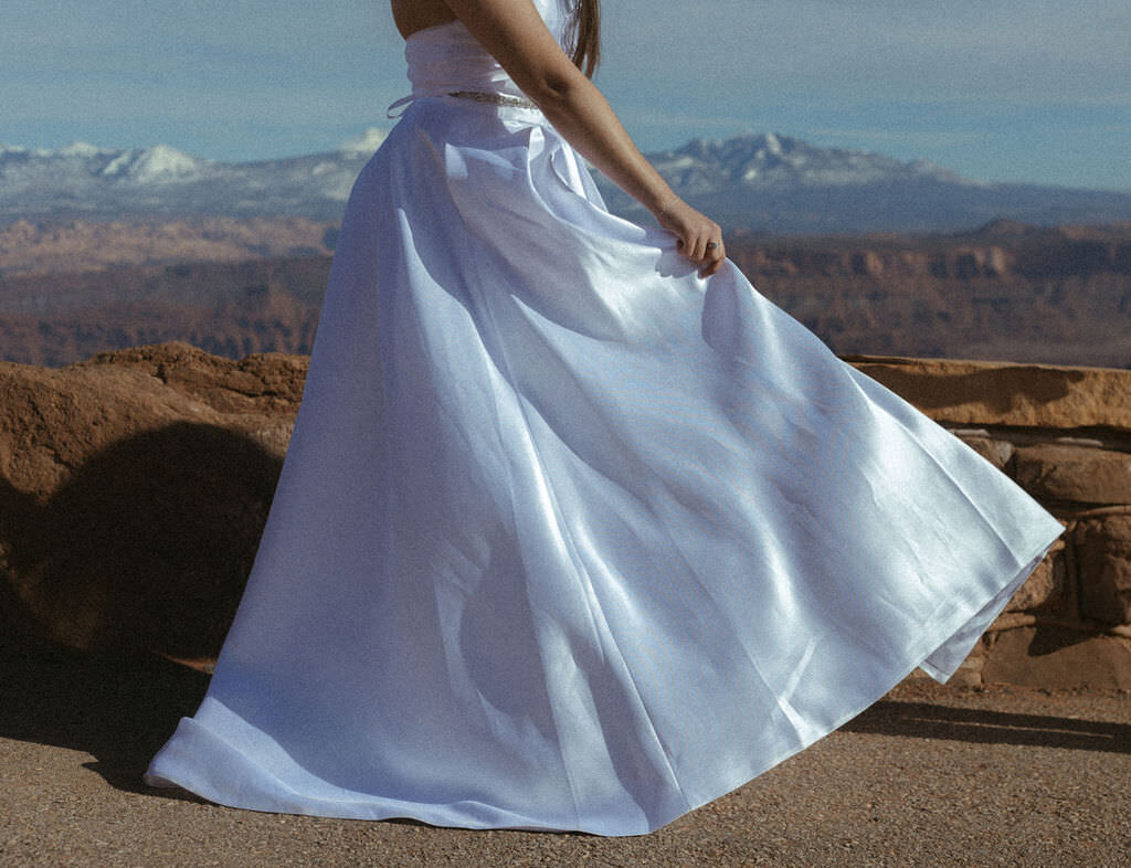 A person holding out the front of their wedding dress.