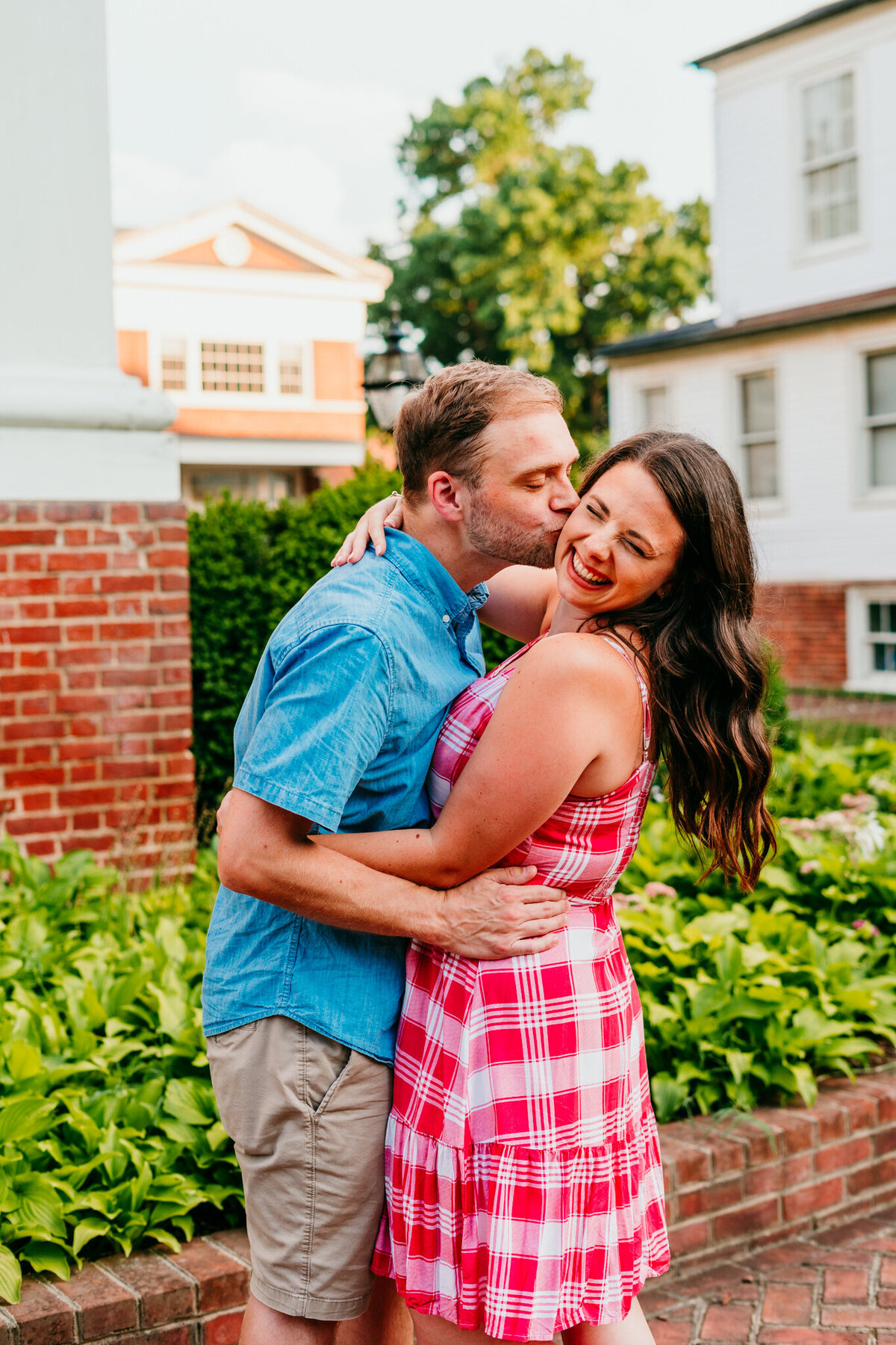 Couple hugging and laughing in front of a historic brick building