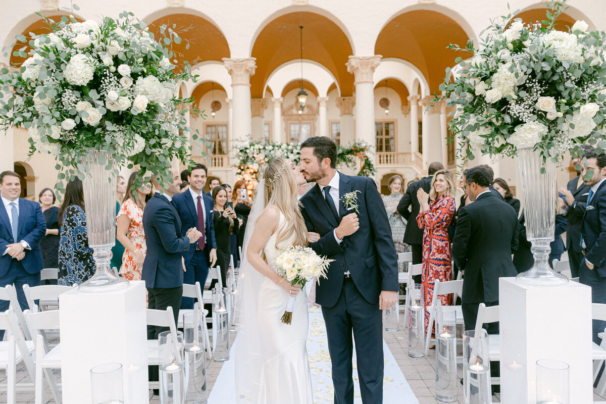 Romantic wedding ceremony exit at a Miami hotel courtyard, surrounded by joyful guests.