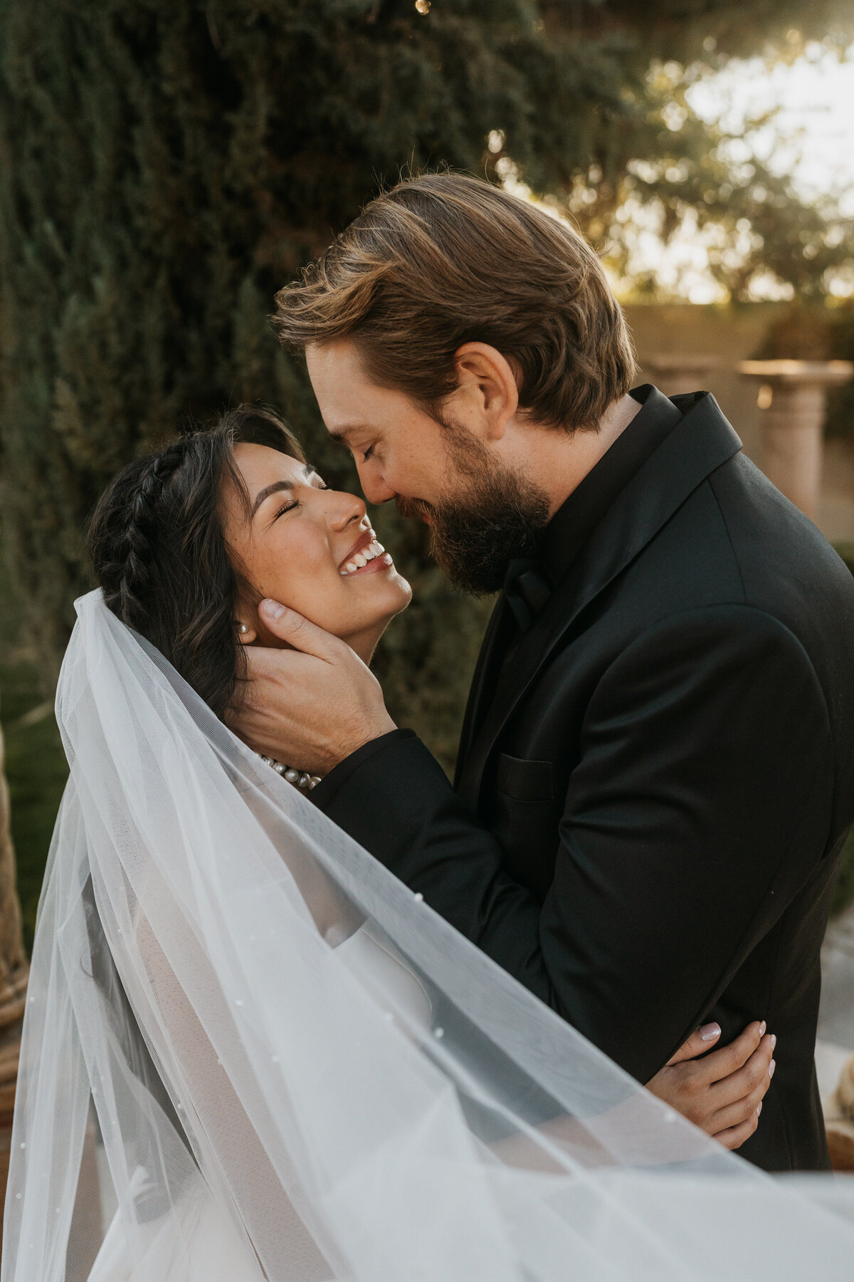 A newlywed couple standing close about to kiss 