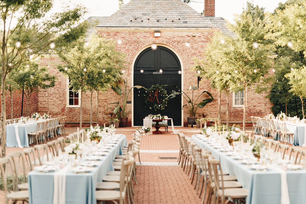 Wedding reception set-up at an outdoor space  with fairy lights and brick features.