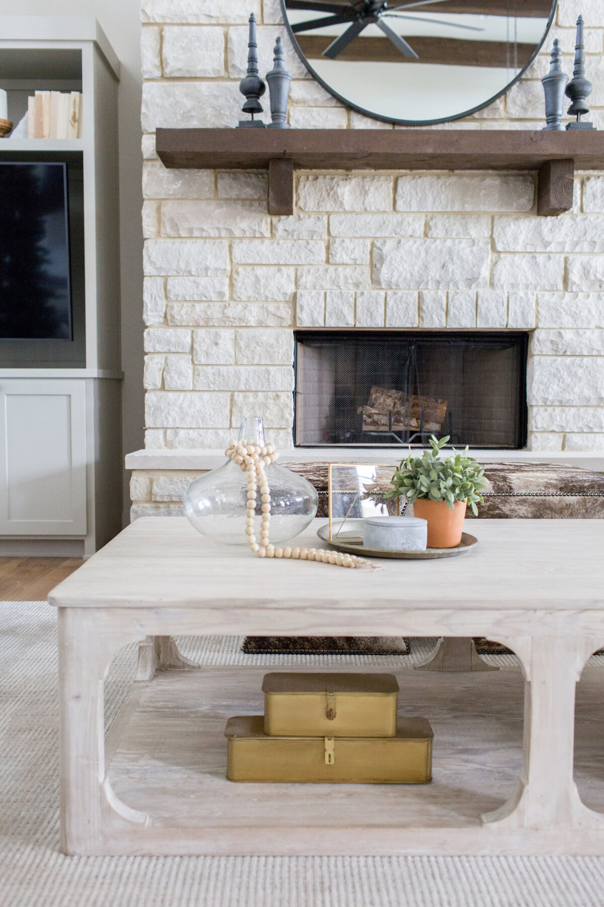 stone fireplace with wood mantle and modern table