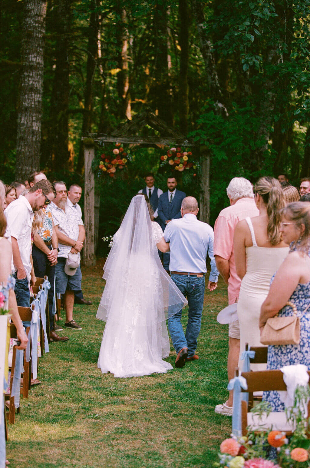 A bride walks down the aisle at an outdoor vintage garden wedding.