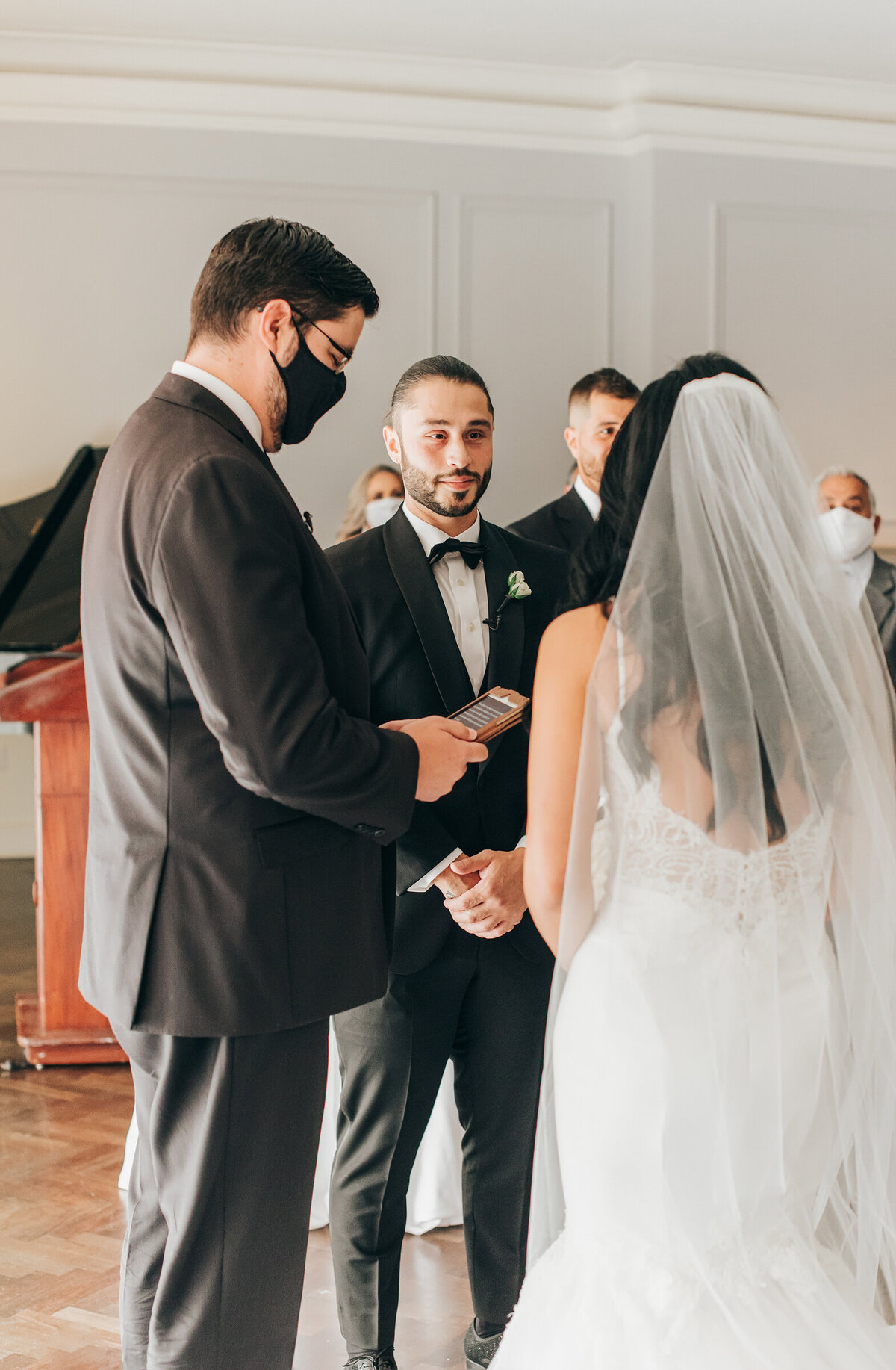 Bride and groom saying their vows during their black tie wedding ceremony
