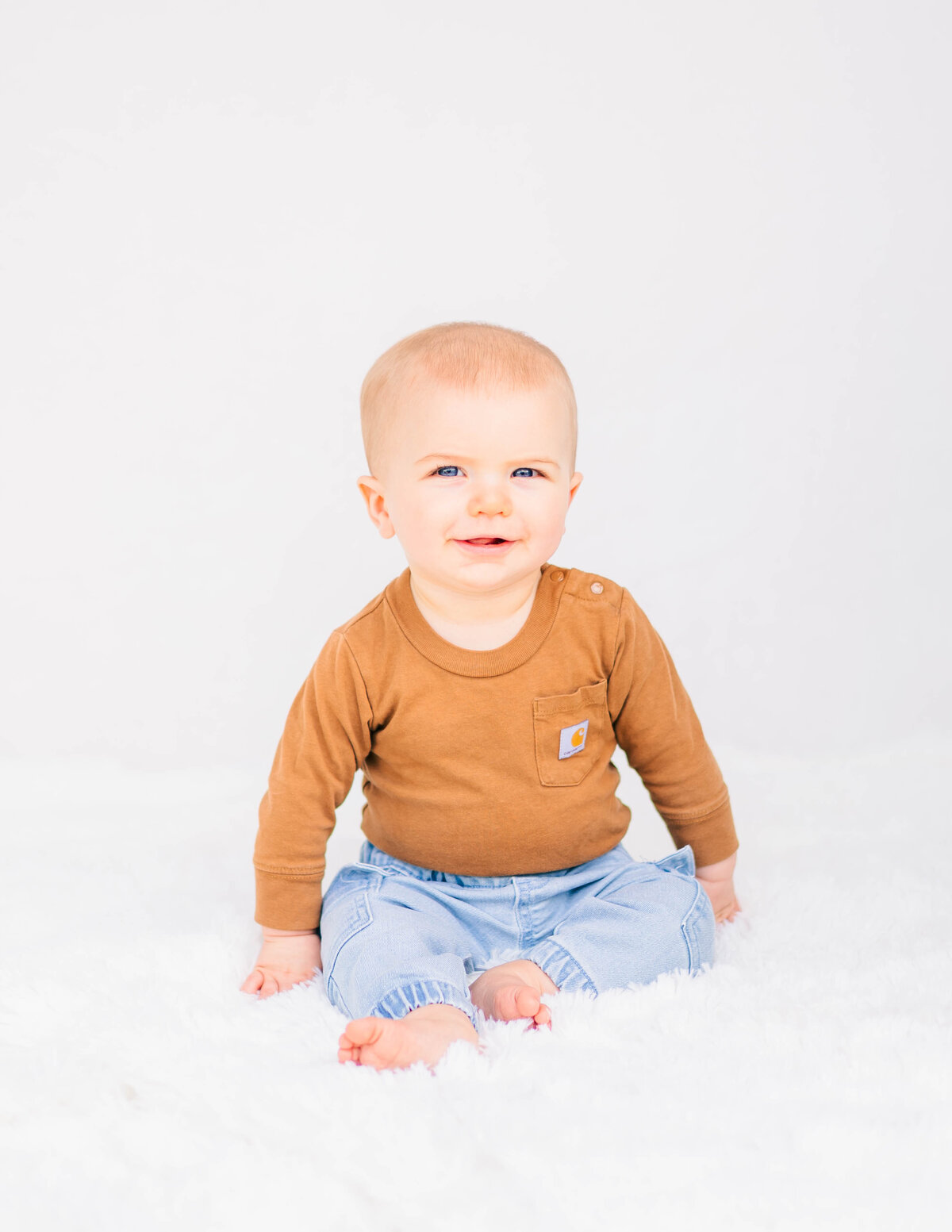 Fine art baby portrait showing joyful expression, clean white backdrop