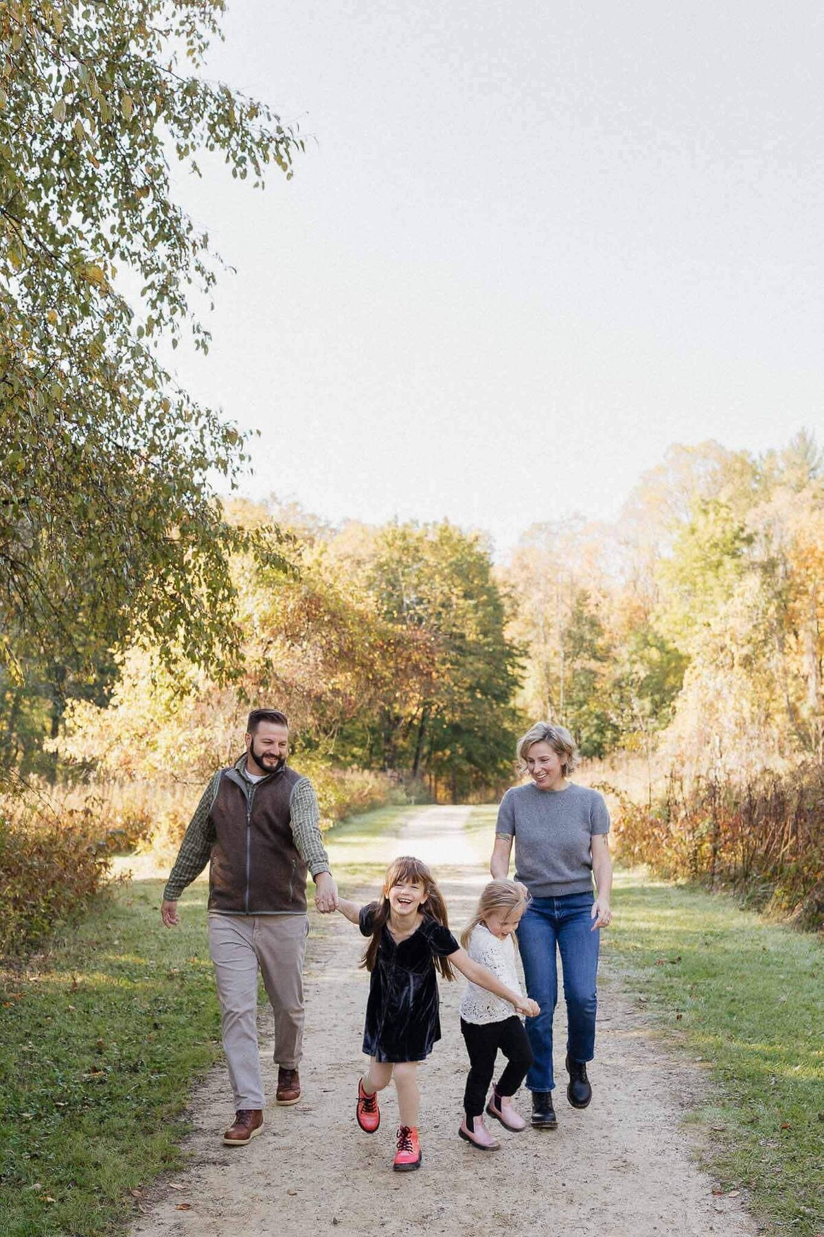 A family enjoying a fall walk through a Cleveland Metropark trail. Captured by a Cleveland family photographer, showcasing candid moments.