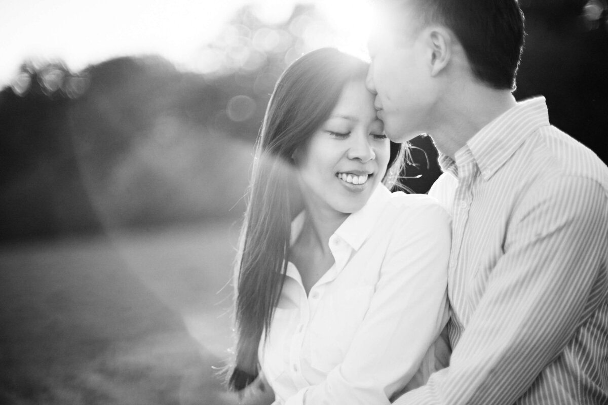 A black and white engagement photo of a couple in a field