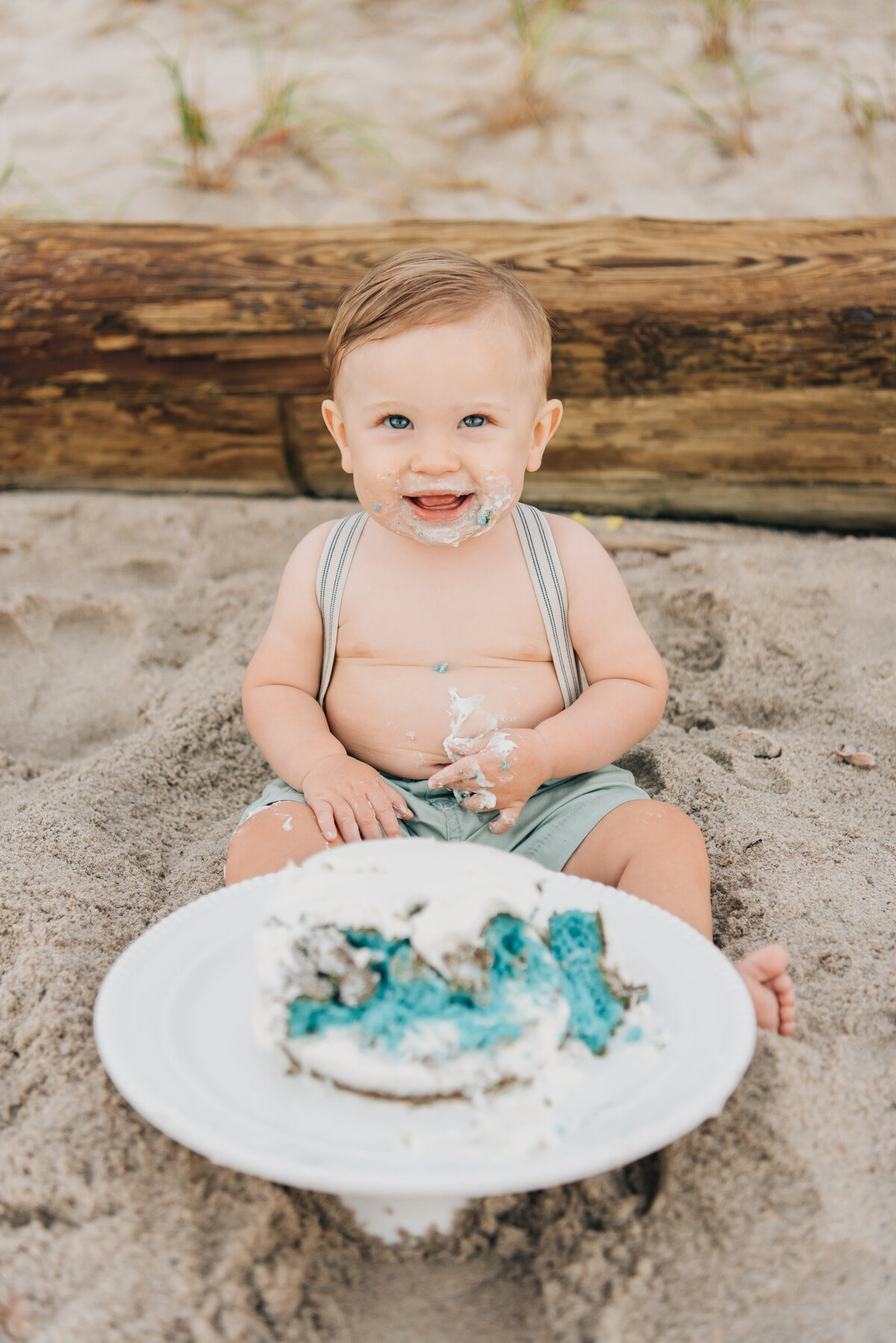 Baby eating cake on beach